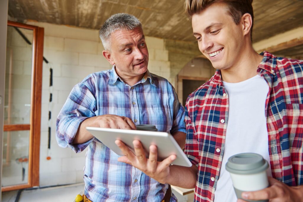 Two people talking and one pointing to a tablet